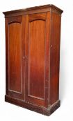 A 19th century mahogany double door wardrobe, moulded cornice above two arched panelled doors, the