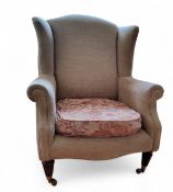 A Victorian style wingback armchair, tapered legs, upholstered in cream