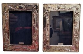A pair of silver Art Nouveau style rectangular easel photograph frames, embossed with sinuous
