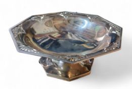 A George V silver octagonal pedestal comport, the angles pierce with ribbon tied foliage, 23cm wide,