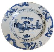 An 18th century English Delft circular charger, typically decorated in underglaze blue with stylised