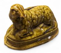 A 19th novelty money bank, in the form of a reclining sheep, green glazed, oval base, 8.5cm high,