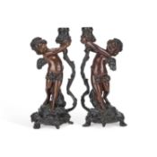 A PAIR OF BRONZE FIGURAL CANDLESTICKS