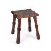 AN ARTS AND CRAFTS FOLK ART CARVED OAK STOOL