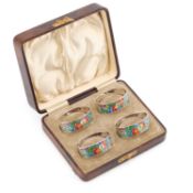 A SET OF FOUR ARTS AND CRAFTS SILVER AND ENAMEL NAPKIN RINGS