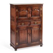 AN OAK PANELLED CABINET IN THE STYLE OF TITCHMARSH & GOODWIN