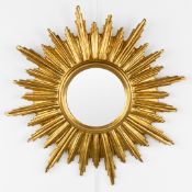 A mid-century sunburst mirror, convex glass. Gilt resin. Circa 1970.