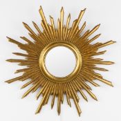 A mid-century sunburst mirror, convex glass. Gilt and sculptured wood. Circa 1970.