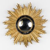 Deknudt, A mid-century sunburst mirror, convex glass. Gilt resin. Circa 1970.