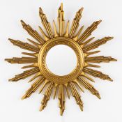 A mid-century sunburst mirror, convex glass. Gilt and sculptured wood. Circa 1970.