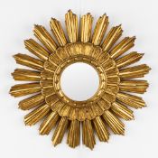 A mid-century sunburst mirror, convex glass. Gilt resin. Circa 1970.