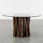 A Large Round Dining Table with a Black Bamboo Base and a Glass Top.