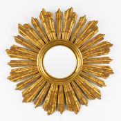 A mid-century sunburst mirror, convex glass. Gilt and sculptured wood. Circa 1970.