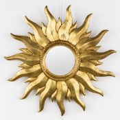 A mid-century sunburst mirror, convex glass. Gilt resin. Circa 1970.