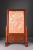 A Chinese carved soapstone dragon panel in later rosewood table screen