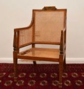 A 19th century caned and painted satinwood armchair