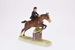 Beswick model of a young woman riding sidesaddle on a jumping horse