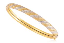 A HIGH KARAT TWO TONE TEXTURED GOLD BANGLE