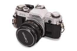 A CANON AT-1 SLR CAMERA, WITH 35-70MM ZOOM LENS, 28MM WIDE ANGLE LENS, AND OTHER ACCESSORIES