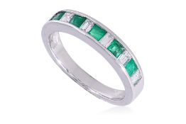 A CHANNEL SET EMERALD AND DIAMOND RING