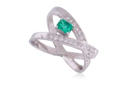 AN EMERALD AND DIAMOND CROSSOVER RING