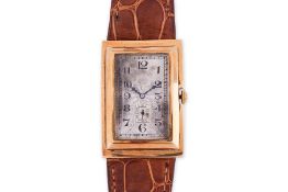AN ART DECO GOLD CURVED RECTANGULAR WATCH