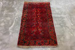 AN ANTIQUE PERSIAN WOOL RUG (193 x 110CM)