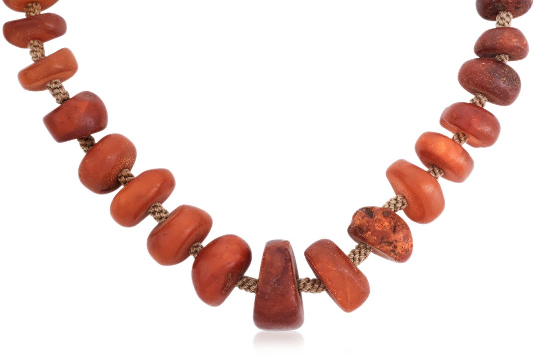 A POLISHED AMBER NECKLACE - Image 1 of 2