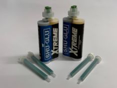 A box of twelve Shu-Glu Xtreme Cold weather bovine block adhesive with a bag of mixer tips. As new