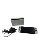 Pre-owned Nintendo Switch OLED Handheld Console (M/N: HEG-001) with dock and charger.