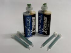 A box of twelve Shu-Glu Xtreme Cold weather bovine block adhesive with a bag of mixer tips. As new