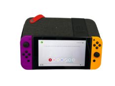 Pre-owned Nintendo Switch console with assorted game cards and case.