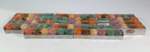 Forteen packs of decorative pillar candles, various scents, eighty four total, some packaging slight