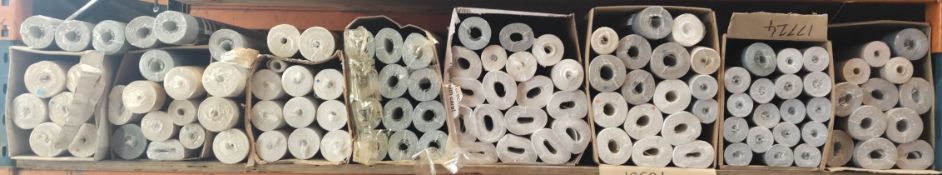 Approximately one hundred rolls of assorted wallpaper.