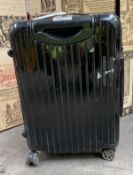 A pre-owned Rimowa Salsa Deluxe hard case wheeled suitcase with some knocks and scratches.