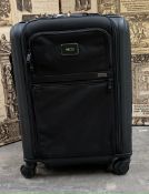 A pre-owned Tumi hard shell wheeled suitcase.