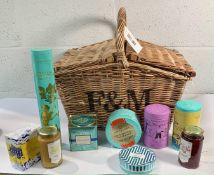 A Fortnum & Masons medium wicker picnic basket to include nine Fortnum & Masons food items; jams, bi