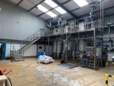 Four large stainless steel mixing/holding tanks with a stainless steel bulk IBC filling station