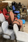 A large quantity of office chairs including swivel and stacking chairs.