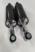 A set of motorcycle adjustable shock absorbers, black.