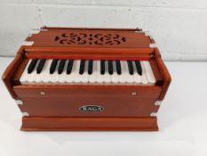 A pre-owned Raga mini harmonium (sold as seen).