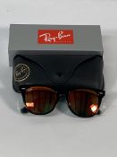A pair of Ray-Bans Wayfarer Flash sunglasses in black with grey mirror orange lenses (RB2140 901-69)