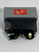 A pair of Ray-Bans Square sunglasses in black and red with G-15 green classic lenses (RB6102).