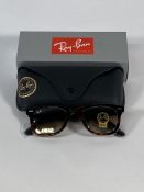 A pair of Ray-Bans Wayfarer Classics sunglasses in tortoise and light brown lenses (RB2140).