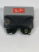 A pair of Ray-Bans Irregular sunglasses in polished black with G-15 green classic lenses (RB3707).