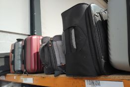 A shelf of preowned luggage (8 items in total).