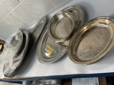 Fourteen assorted stainless steel oval plates (may show signs of long term storage).