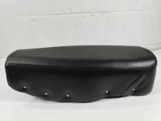 A re-upholstered seat for a classic motorcycle, black with studs on edging, unknown fitment.