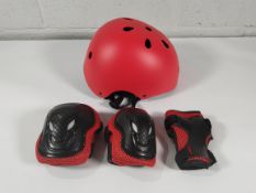 A large amount of XJD Kids Helmets with elbow/knee pads and wrist guards, various sizes and colours.