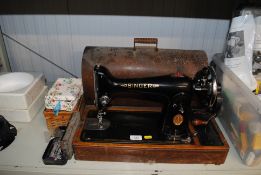 A Singer sewing machine in fitted case together wi